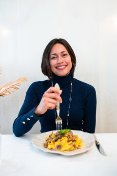 Vertical portrait Smiling woman enjoying homemade tagliatelle pasta with mushrooms at home