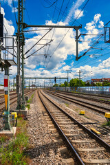 Expansive platform beneath cloudy sky, linear perspective conveying motion at railway transit point