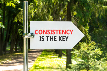 Consistency is the key symbol. Concept words Consistency is the key on beautiful white road sign. Beautiful green garden background. Business consistency is the key concept. Copy space.