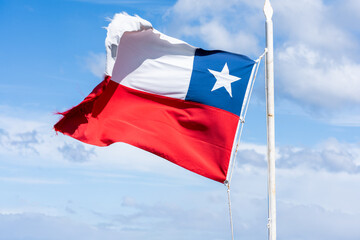 National flag of Chile waving in the wind against a blue sky