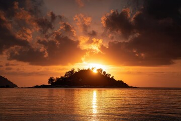Sunset casts golden light on a small island, the sea reflecting the fiery sky