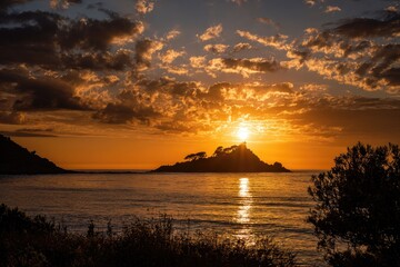 Island silhouetted against a fiery sunset, reflecting on calm ocean water