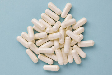 White capsules creating a heap, visualizing medication, pharmacy, health, wellness, treatment, and medical concepts