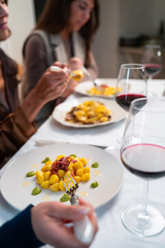 Italian Gnocchi with Bacon and Basil Served at Elegant Dinner Table with Red Wine