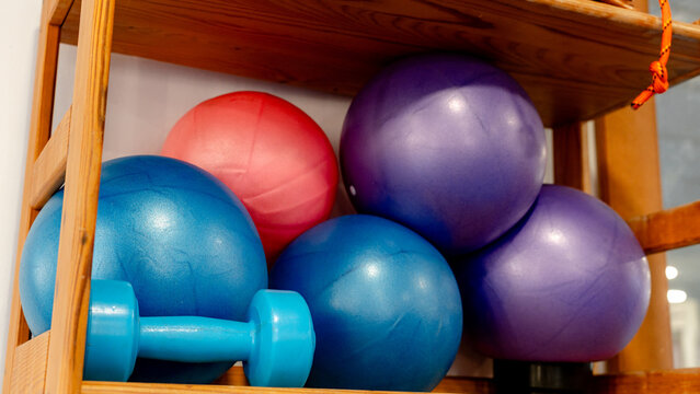 Colorful gym equipment on wooden shelf