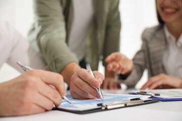 Fototapeta premium Businesspeople working together at table in office, selective focus