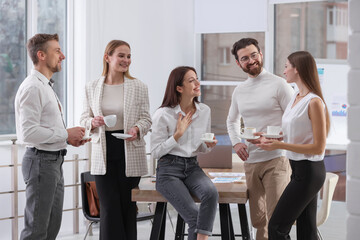 Colleagues with coffee during break in office