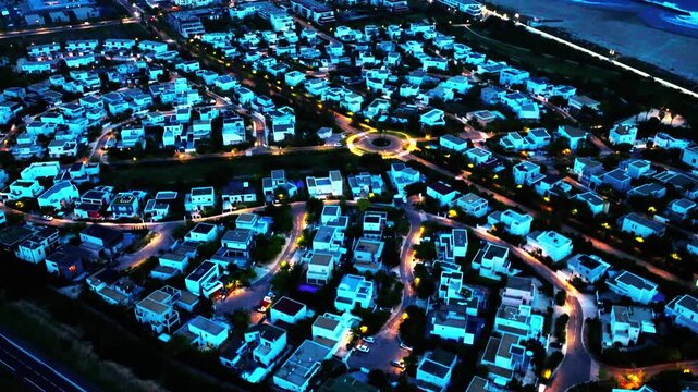 Aerial drone footage of Sete city at night, featuring illuminated urban landscape, harbor lights