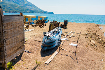 Kayak and beach equipment placed on a quiet seaside shore. Leisure preparation, coastal recreation, and simple seaside lifestyle before tourist activity.