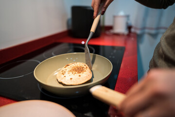 Woman cooking homemade pita bread on stovetop
