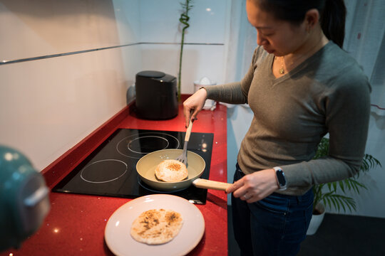 Woman cooking homemade pita bread in modern kitchen