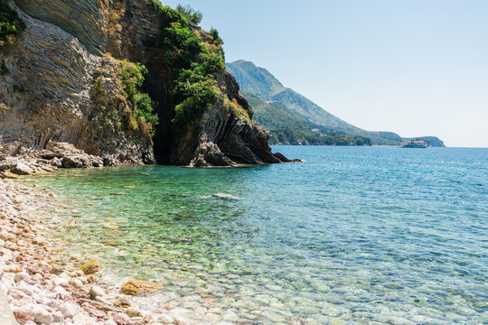 Hidden rocky cove with crystal clear water along Budva coast in Montenegro. Secluded recreation, coastal purity, and immersive connection with untouched Adriatic nature.