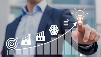 A person in a blue suit pointing at a light bulb with a brain and factory on a rising graph with a city background