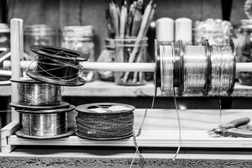 Wire craft supplies on an authentic workspace in black and white