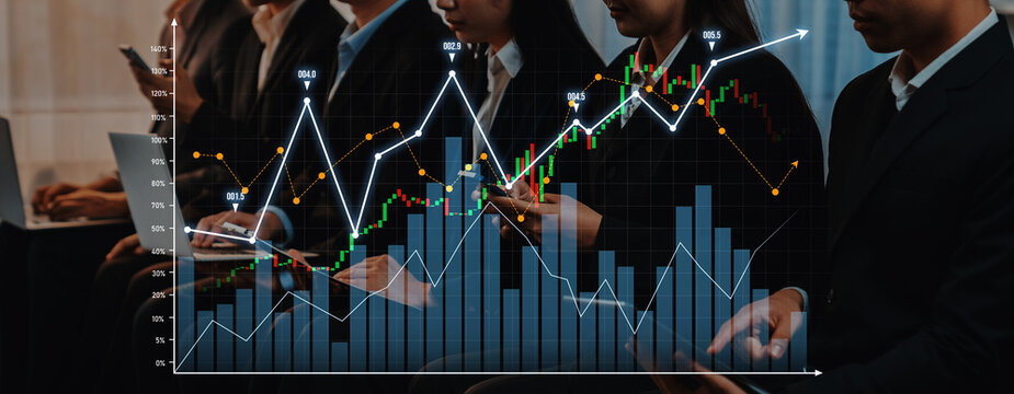 A focused business team analyzes financial trends with laptops, observing stock market graphs and charts, showcasing a modern workspace dedicated to strategy. Scalp - Powered by Adobe