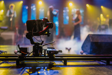 Valmiera, Latvia - December 29, 2025: Camera on a dolly track capturing a live music performance with vibrant stage lights and smoke effects