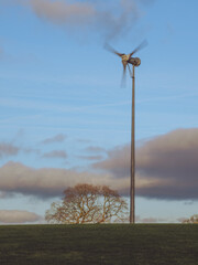 A small wind turbine in a field used on a farm