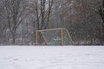 Soccer goal on snowy field during winter snowfall