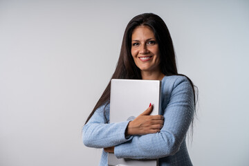 Fototapeta premium Smiling businesswoman holding laptop computer and looking at camera on isolated gray background.