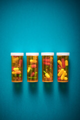 Pills in orange plastic bottles on a blue table.