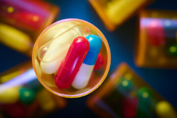 Pills in orange plastic bottles on a blue table.