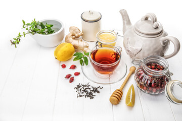Cup tea with honey lemon and Rose Hip on white wooden board top view. Medicinal drink with mint and...