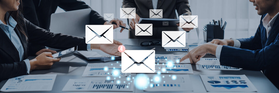 A diverse business team collaborates in a modern office setting, focusing on email strategies while analyzing graphs and charts for improved communication and productivity. Trope - Powered by Adobe