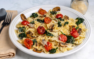 farfalle top with sauteed spinach and tomatoes