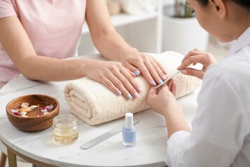 Manicure spa treatment nail care service. A nail technician in a white shirt applies blue nail polish to a female client wearing a pink shirt