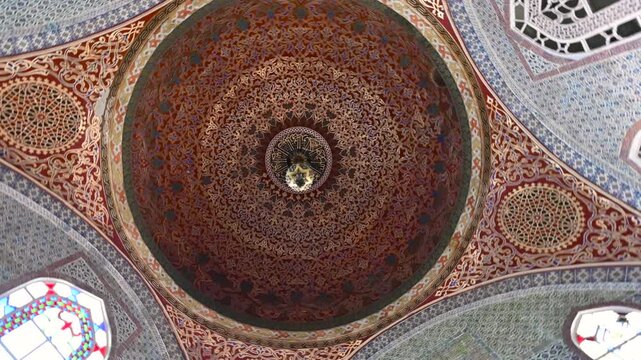 Istanbul, Turkey, August 1, 2025. Intricate ottoman dome at topkapi palace with gilded islamic patterns, calligraphy and ornate ceiling architecture, historic landmark. Rotation movement.