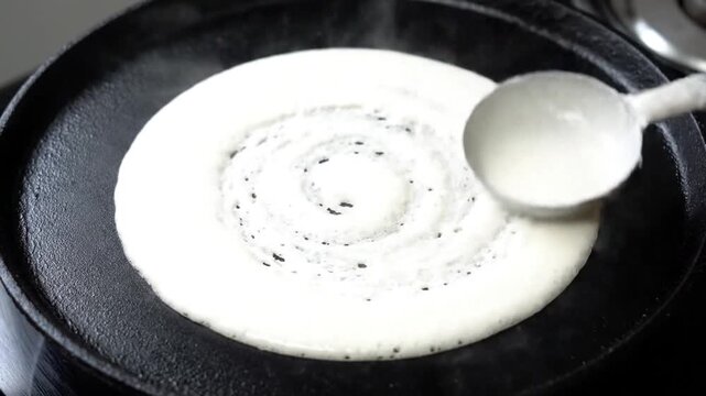 Pouring Dosa Batter On Hot Pan To Prepare Delicious Crispy Dosa With Steel Ladle Close Up View Cooking Process In