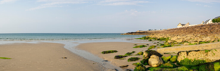 Paisaje panor&aacute;mico del Puerto de Becquet con una gran playa y casas al fondo, viajando por la Normand&iacute;a Francesa en verano de 2022