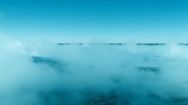 A vast expanse of turquoise water shrouded in mist. The horizon is a thin, dark line against the clear sky.