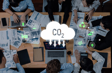A diverse team collaborates on environmental impact analysis, focusing on CO2 emissions data. Charts and graphs illustrate sustainable strategies in a modern office. Trope