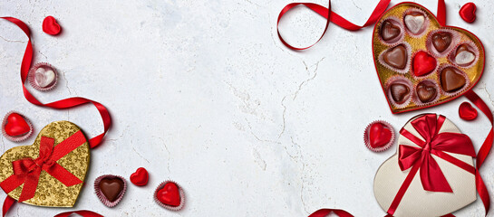 Heart-Shaped Chocolate Boxes and Red Ribbons on White Marble Background. Valentine's day composition with copy space
