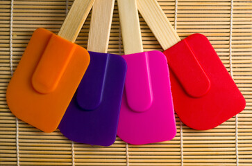 Top View of Multicolored Rubber Kitchen Spatulas on Bamboo Table Top