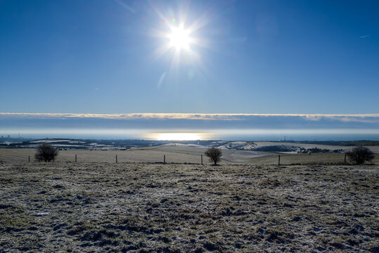 Looking out over snow covered South Downs at Fulking Hill towards the coast at Shoreham and Brighton