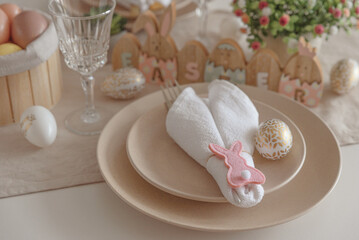 Festive Easter table setting with Easter bunny made from napkin. Easter celebration concept