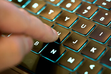 Typing on a laptop keyboard at night