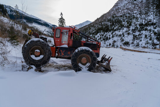 Skidder - Timberjack 208e at a timber yard in the mountains during winter.