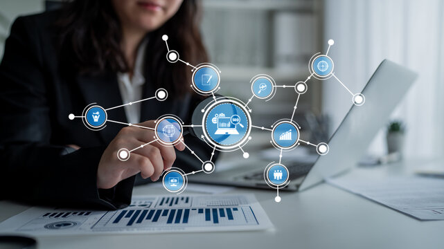 A businesswoman interacts with a digital interface displaying graphs and charts, emphasizing data analysis and strategic planning in a modern office. Tessel - Powered by Adobe