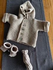 DIY Knitten baby clothes on a wooden background