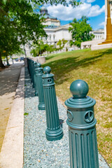Urban life detail with metal bollards along pedestrian path in city park
