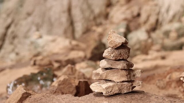 A woman stacks stones one on top of the other, making a wish. Stacking stones into a tower in a cave. Prohodna Cave, popular names &mdash; Eyes of God or Devil&rsquo;s Eyes. Bulgaria