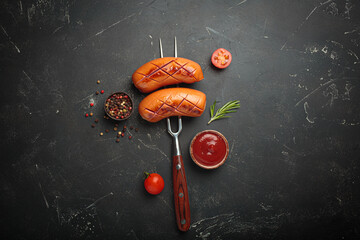 Grilled sausages fork ketchup spices bbq barbecue tomato black background