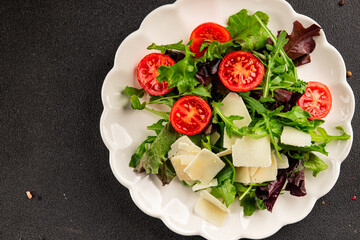 Parmesan cheese vegetable salad tomato, arugula, green leaf lettuce healthy food main course ingredient appetizer fresh tasty gourmet food background food top view copy space vegetarian food