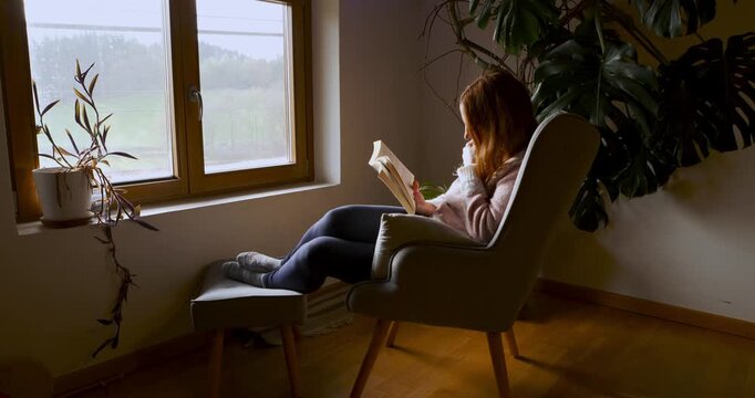 Middle-aged woman enjoying a peaceful moment reading a book. Luz natural y serenidad. Natural light and serenity.