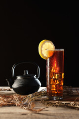 Red Tea With Ice Served on Wooden Table With Tea Pot and Strainer