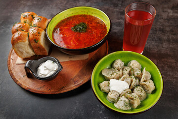 Enjoying a variety of traditional dishes featuring borscht, dumplings, bread, and berry drink from...