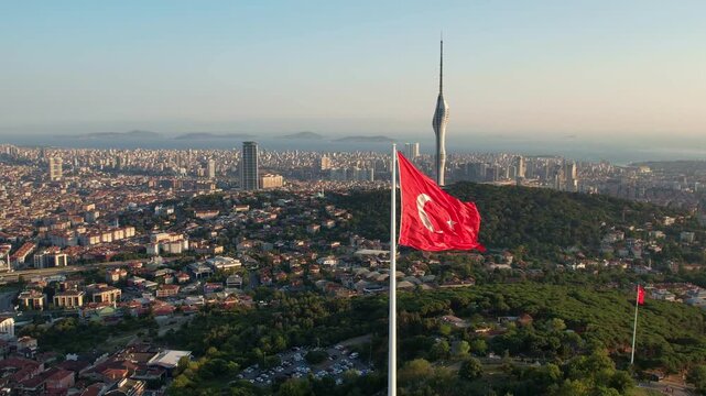 Drone footage showing a large Turkish flag on Camlica Hill with Camlica Tower and the vast Istanbul skyline in clear daylight.